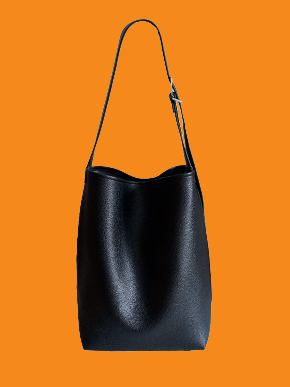 Black leather handbag on an orange background
