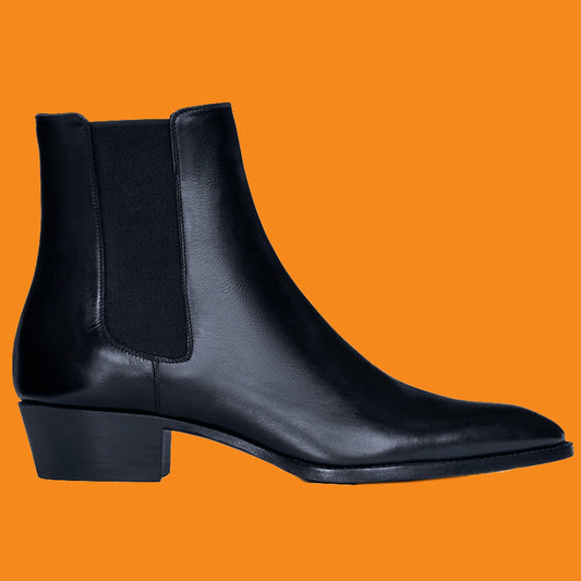 Black ankle boot on an orange background