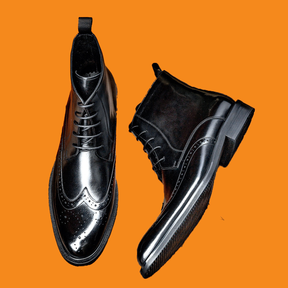 Black dress shoes on an orange background