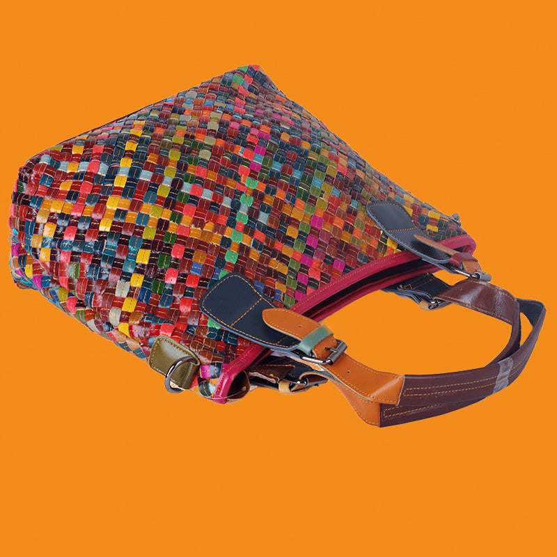 Multicolored woven bag with a brown strap on an orange background