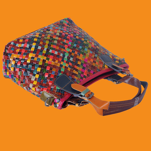 Multicolored woven bag with a brown strap on an orange background