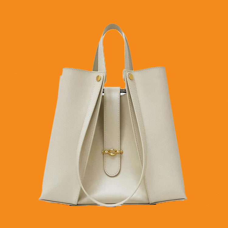Beige handbag with gold accents on an orange background