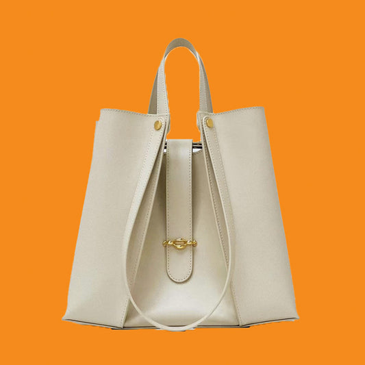 Beige handbag with gold accents on an orange background