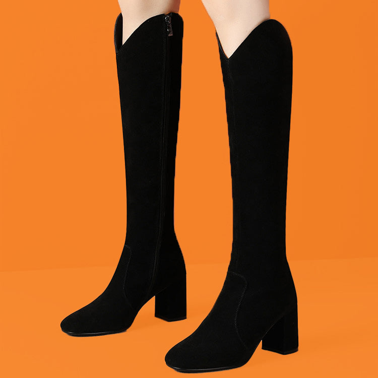 Black knee-high boots on a bright orange background