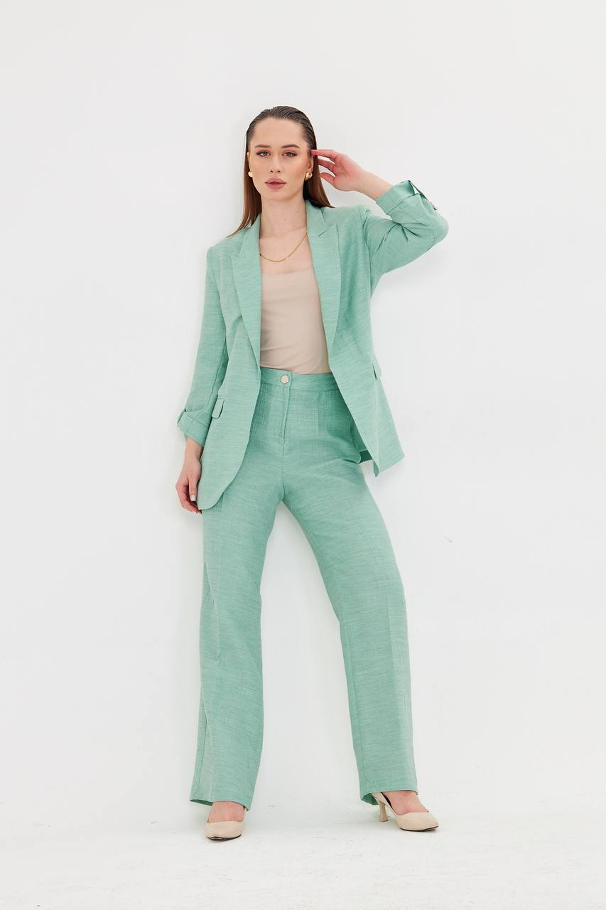 Woman wearing a mint green suit on a white background