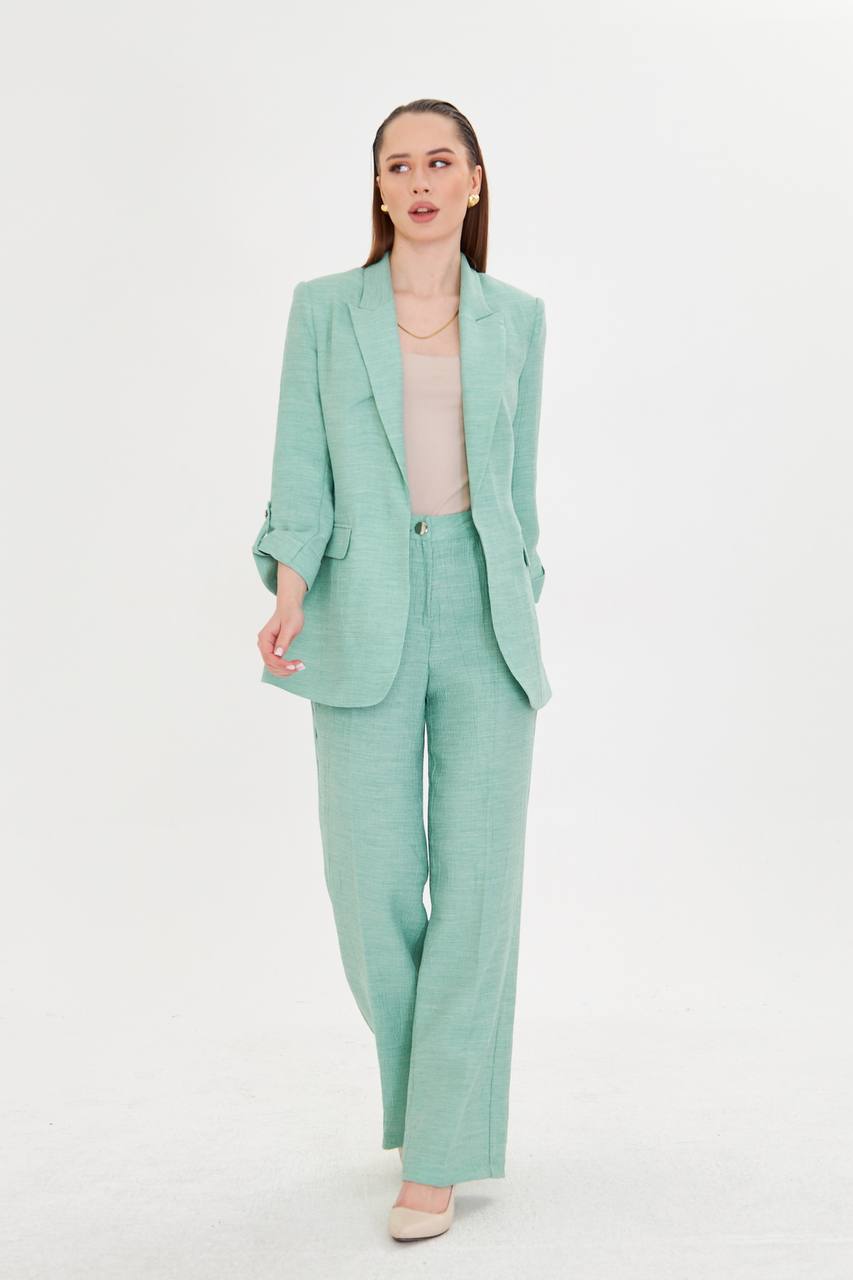 Woman wearing a mint green suit on a white background