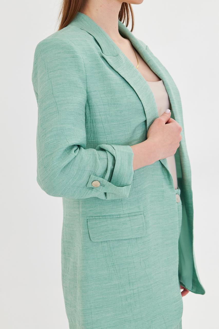 Green blazer worn by a person on a white background