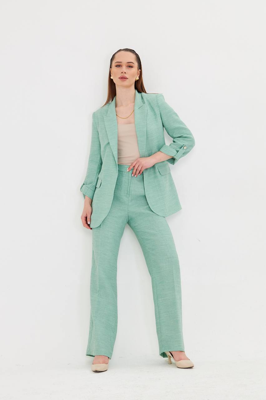 Woman wearing a mint green suit on a white background
