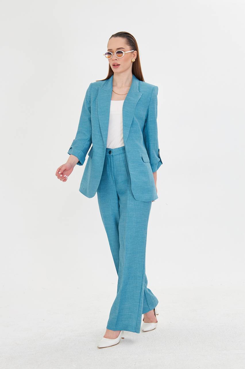 Woman wearing a blue suit with a white top on a white background