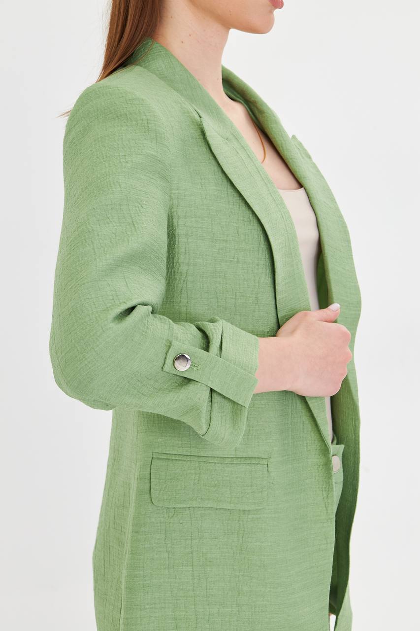 Green blazer worn by a person on a white background