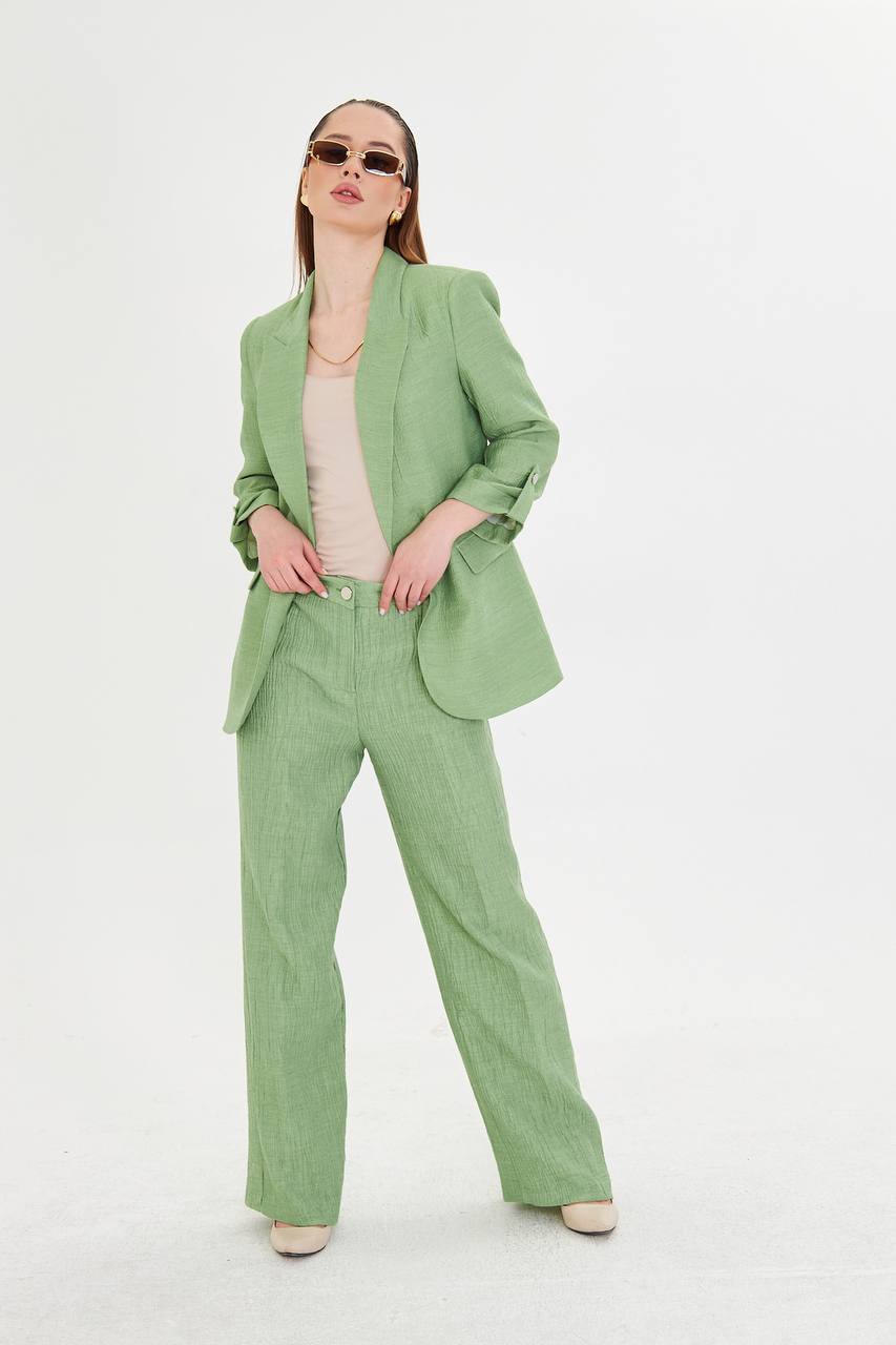 Woman wearing a green suit on a white background
