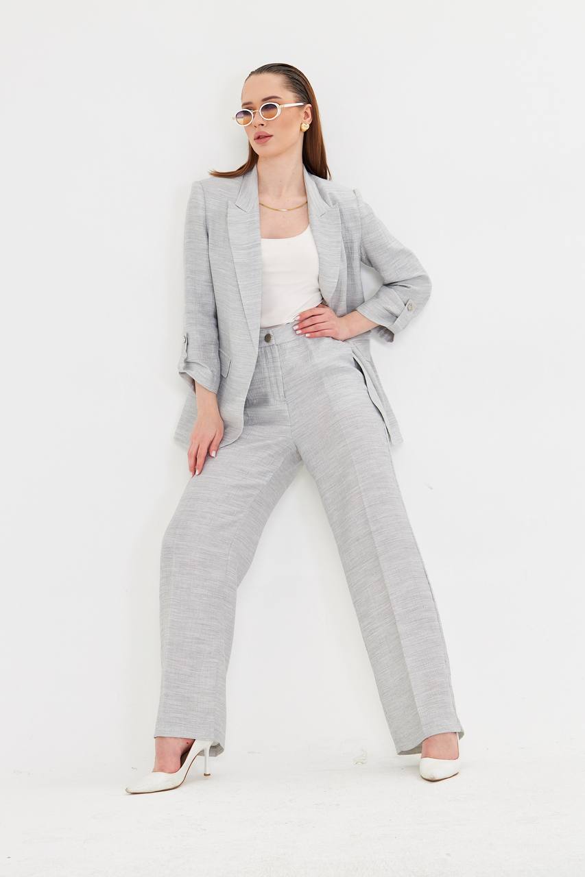 Woman wearing a gray suit with a white top on a white background