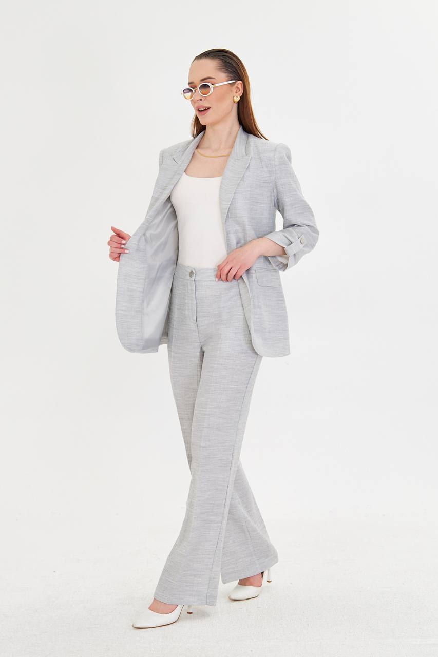 Woman wearing a gray suit with a white top on a white background