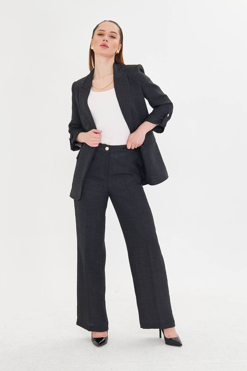 Woman wearing a black suit with a white top on a white background