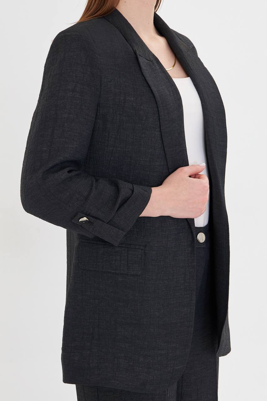 Person wearing a dark gray blazer over a white shirt on a white background