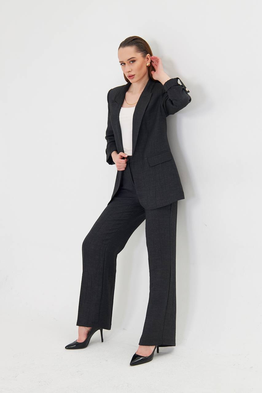 Woman wearing a black suit with a white top on a white background