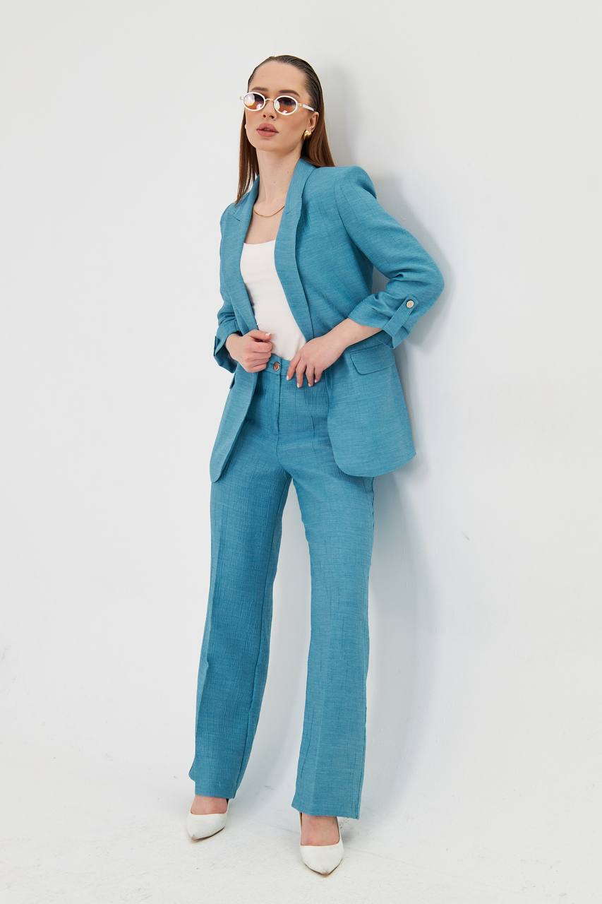 Woman wearing a blue suit standing against a white background