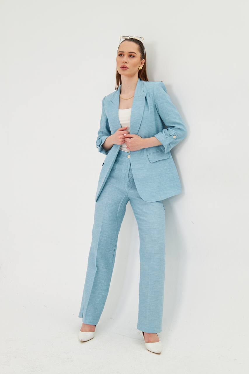 Woman wearing a light blue suit against a white background