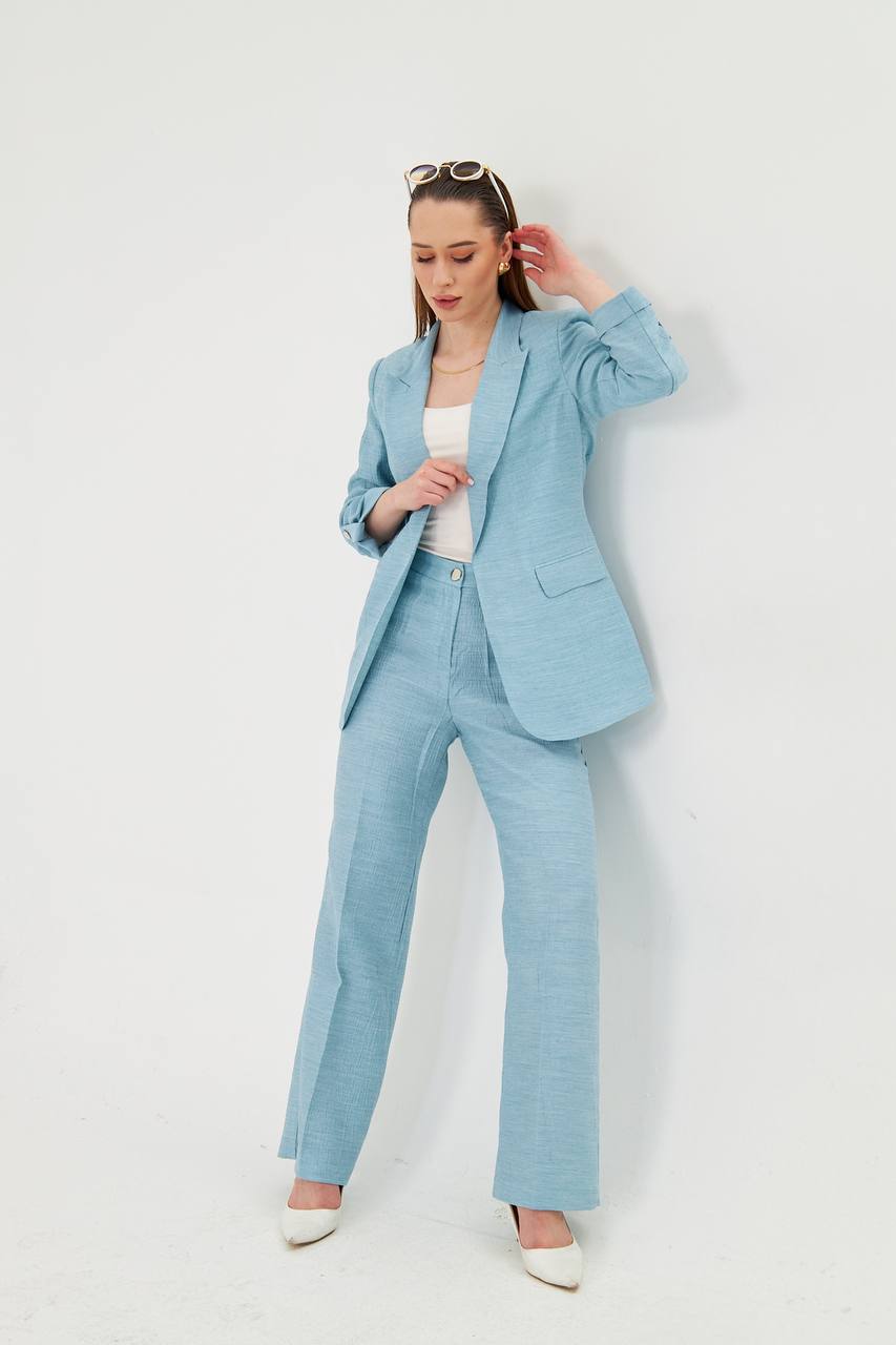Woman wearing a light blue suit against a white background