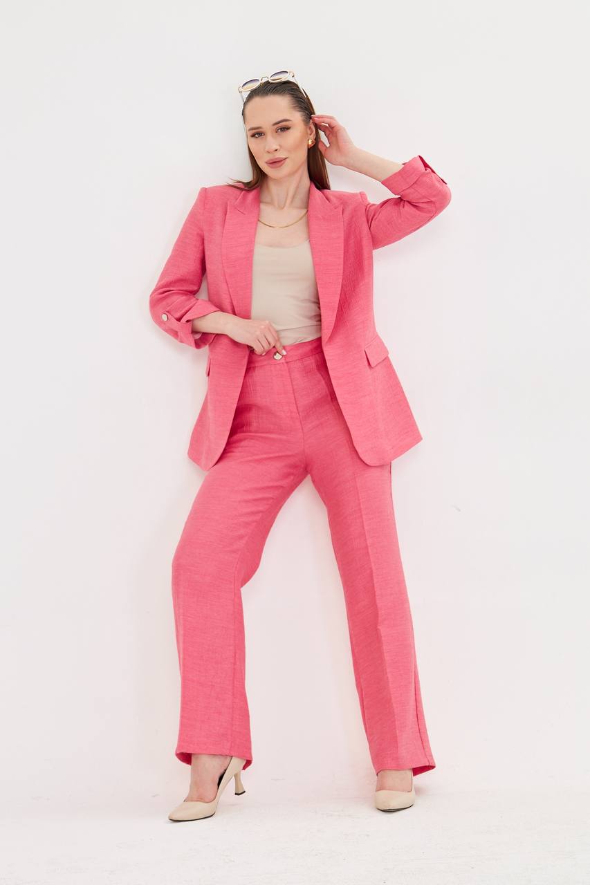 Woman wearing a pink suit against a white background