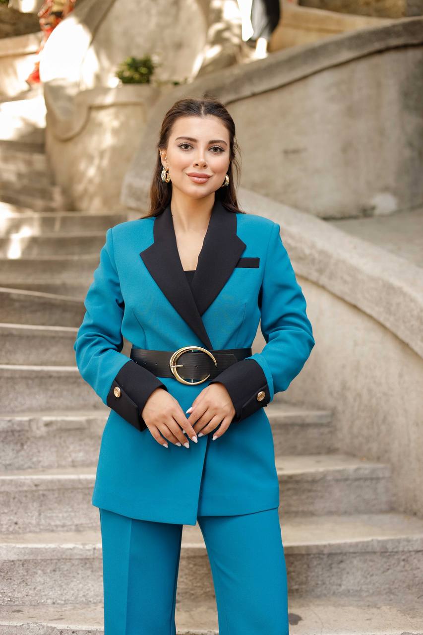 Woman in a blue suit standing on stone steps outdoors