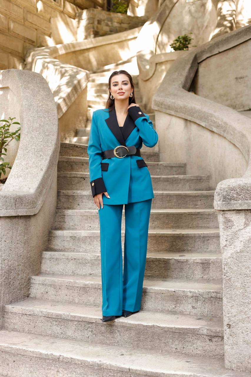 Woman in a blue suit standing on stone steps with architectural background