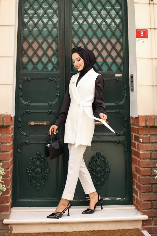 Woman in white outfit standing in front of a green door