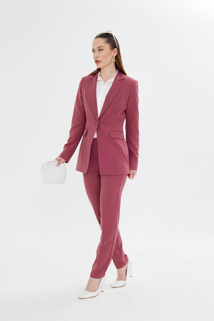 Woman wearing a pink suit with a white shirt on a white background