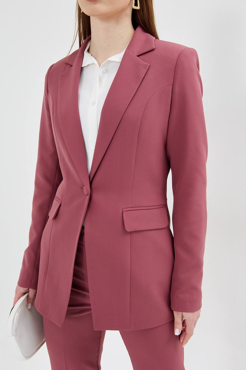 Person wearing a pink suit with a white shirt on a white background