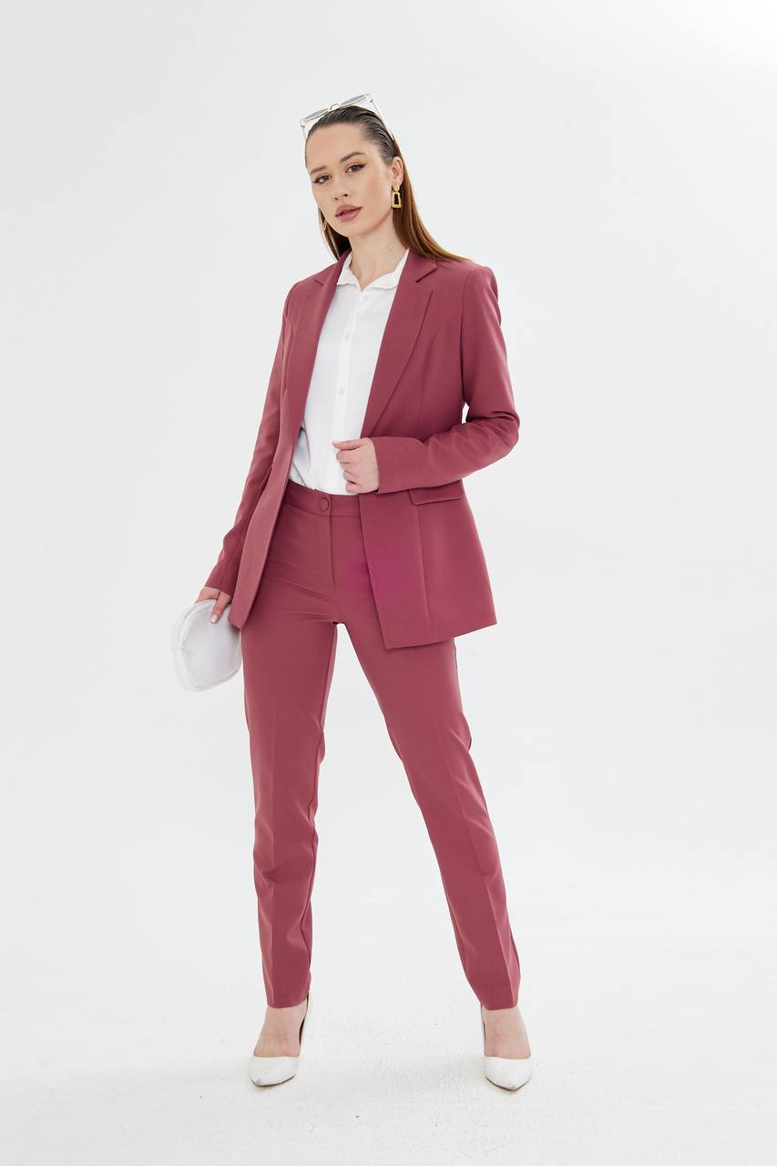 Woman wearing a pink suit with a white shirt on a white background