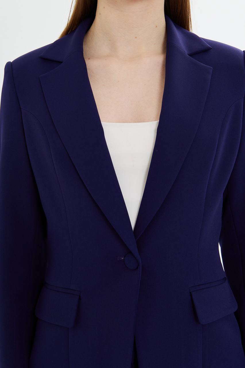 Navy blue blazer worn by a person on a white background