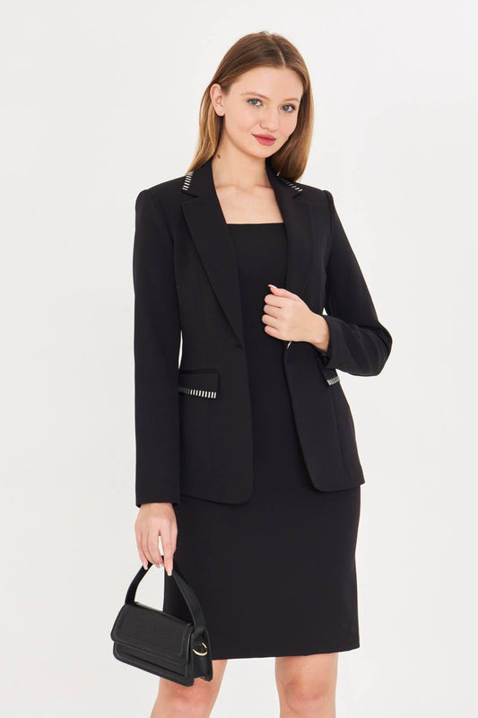 Woman wearing a black blazer and skirt set with a handbag on a white background