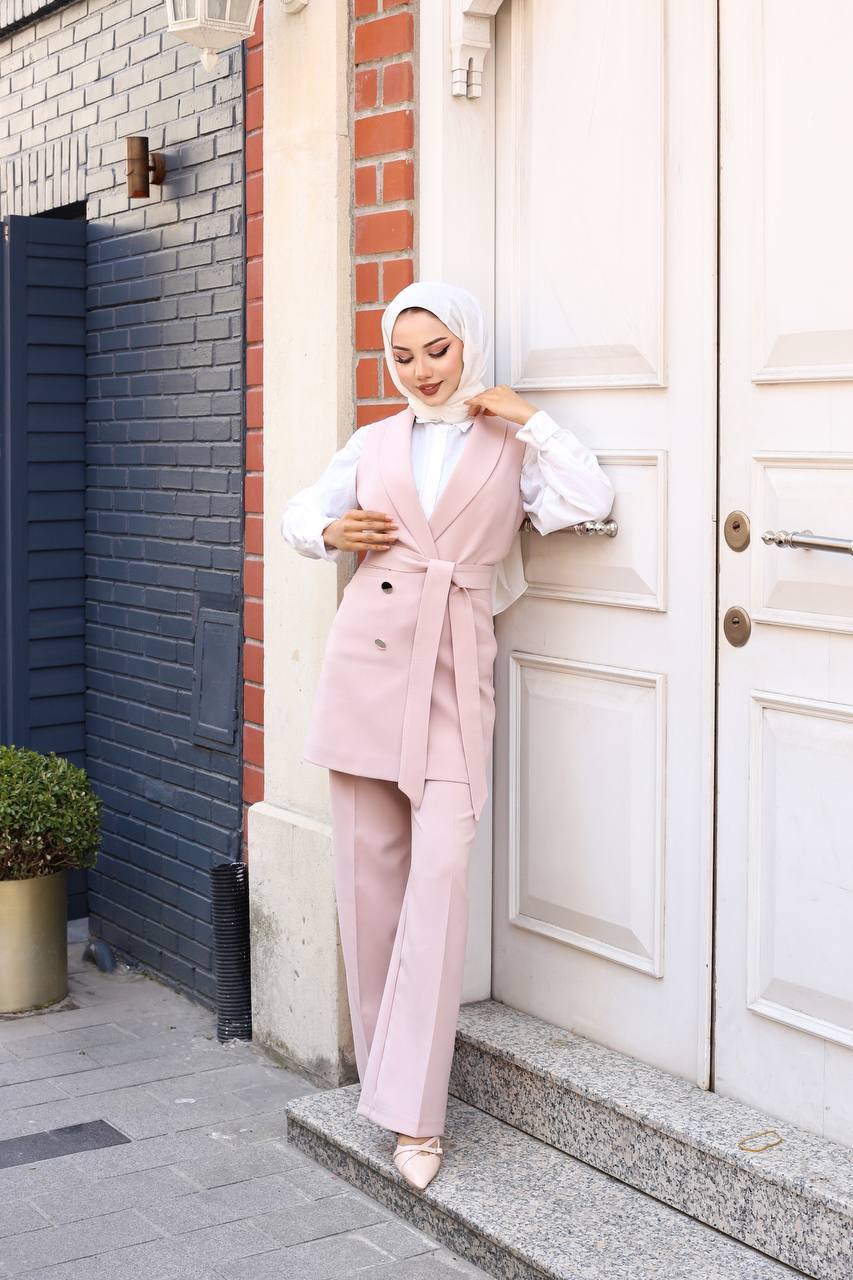 Woman in a pink outfit standing outside a building