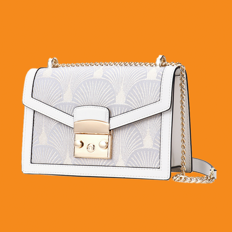 White handbag with gold accents on an orange background