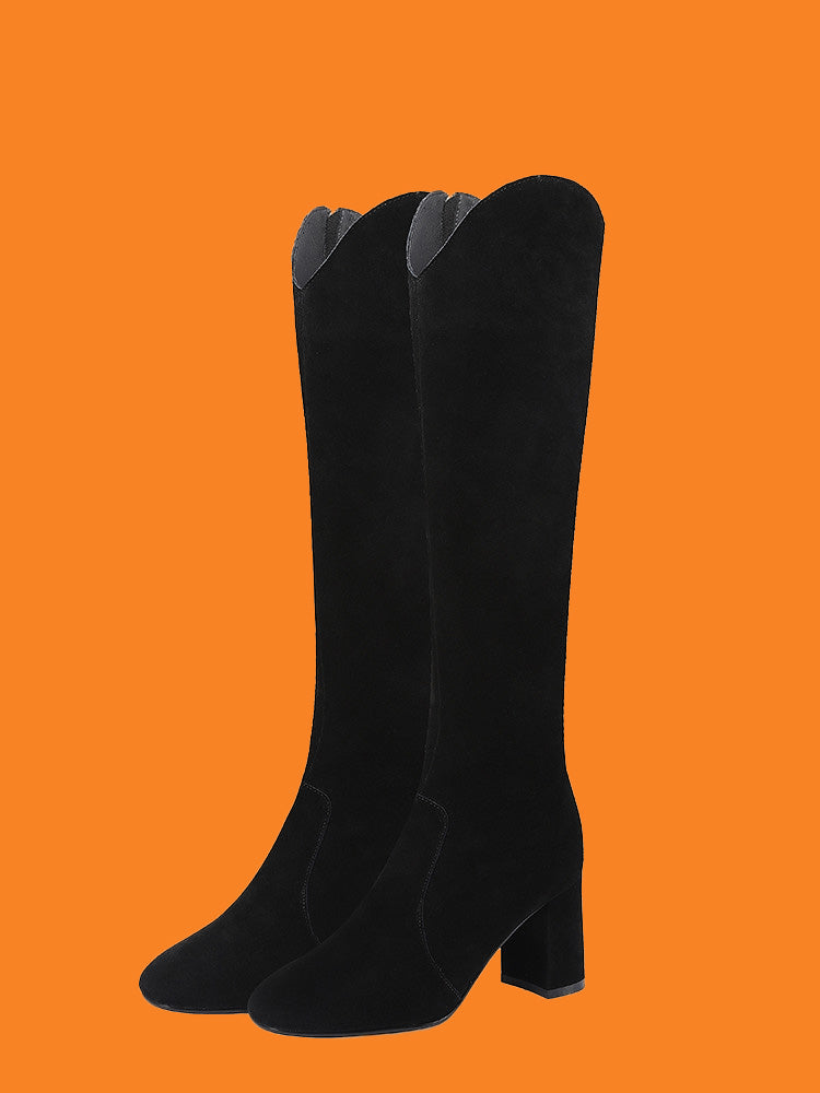 Black knee-high boots on an orange background