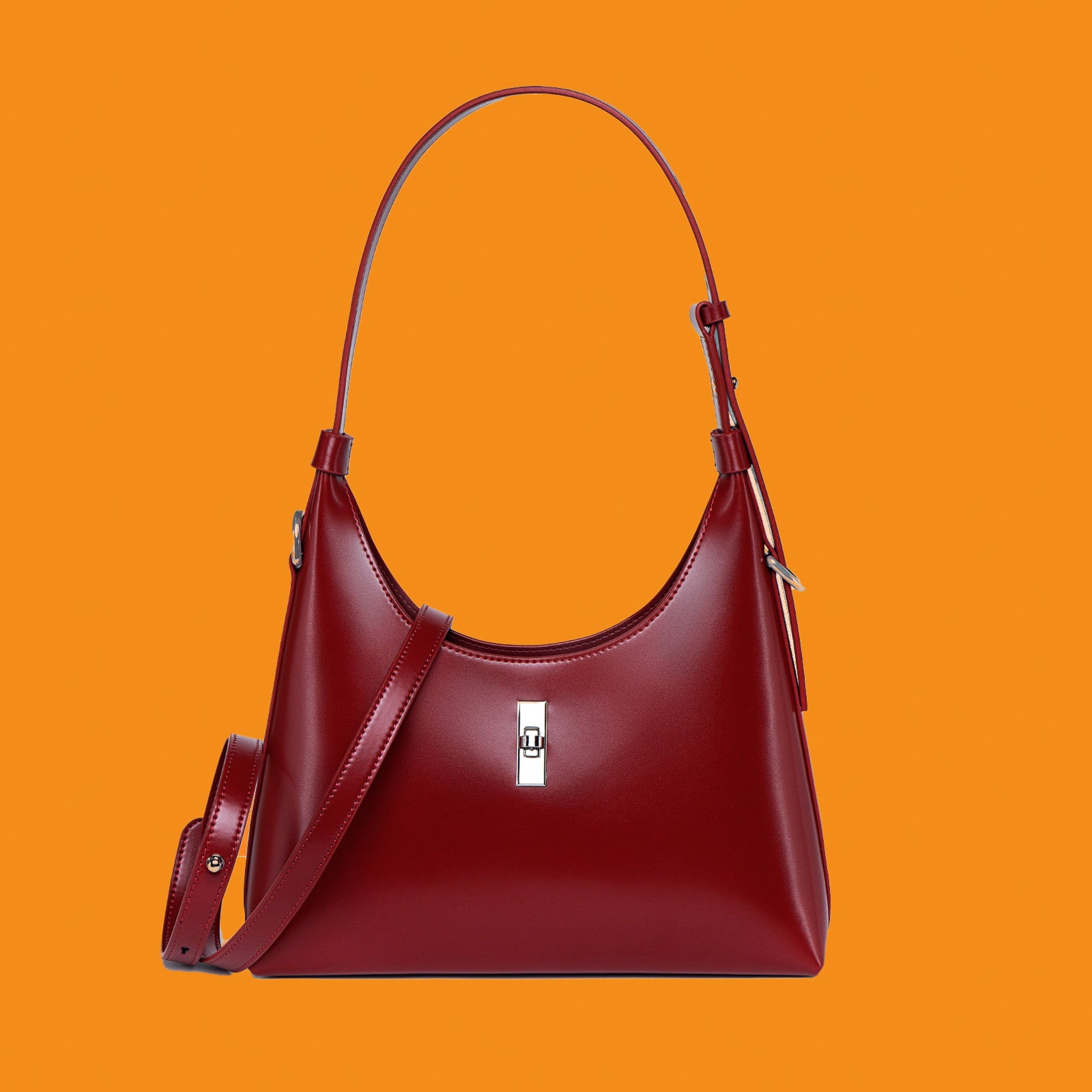 Red handbag with a silver clasp on an orange background