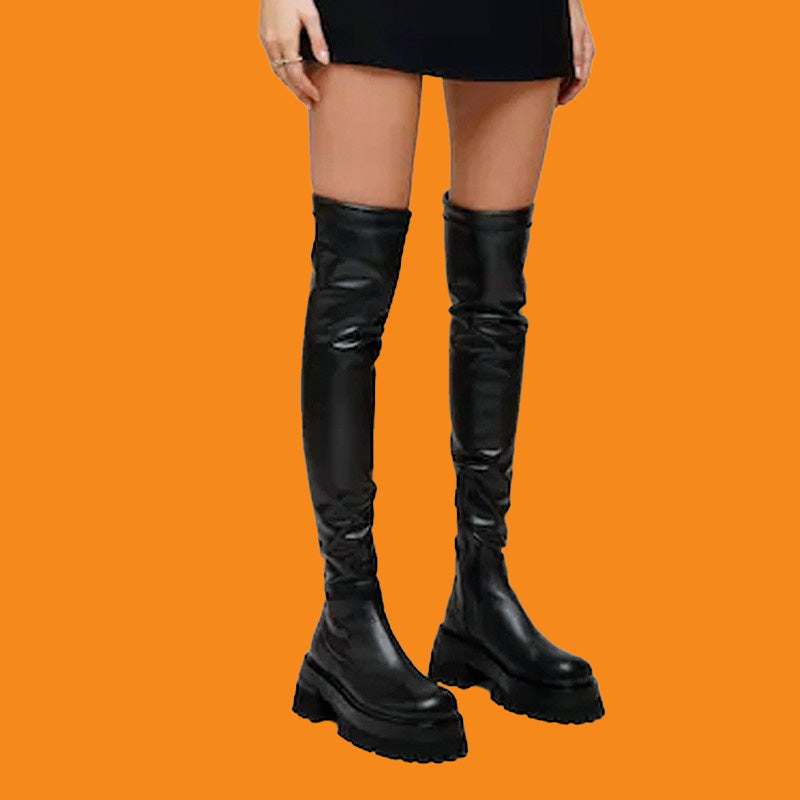 Black knee-high boots on a person against an orange background