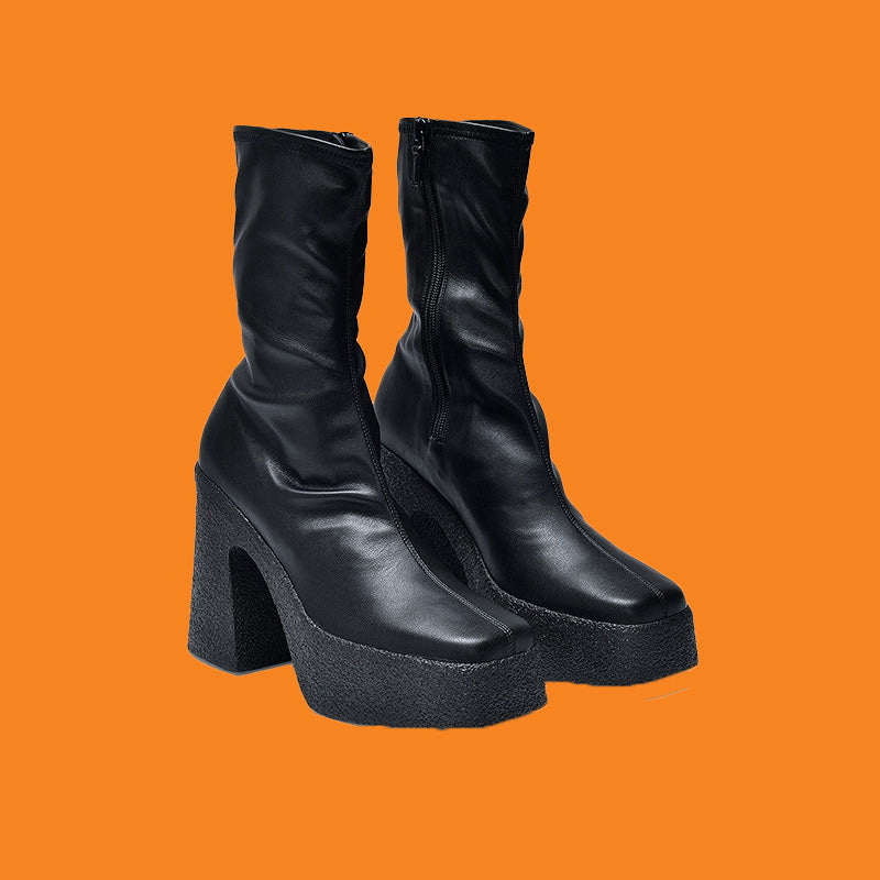 Black platform boots on an orange background