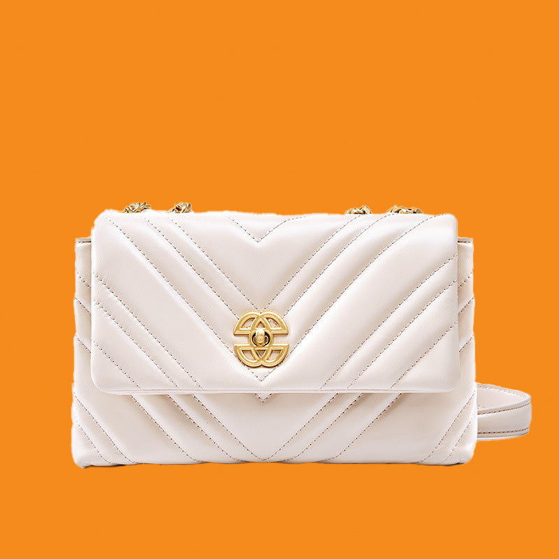 White quilted handbag with gold logo on an orange background