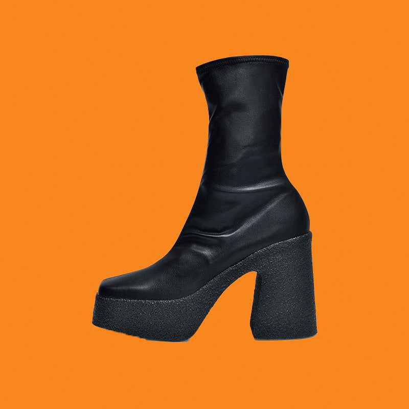 Black leather boot with a thick platform sole on an orange background