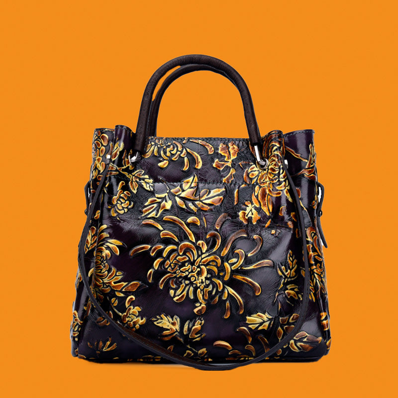 Handbag with gold floral pattern on a bright orange background
