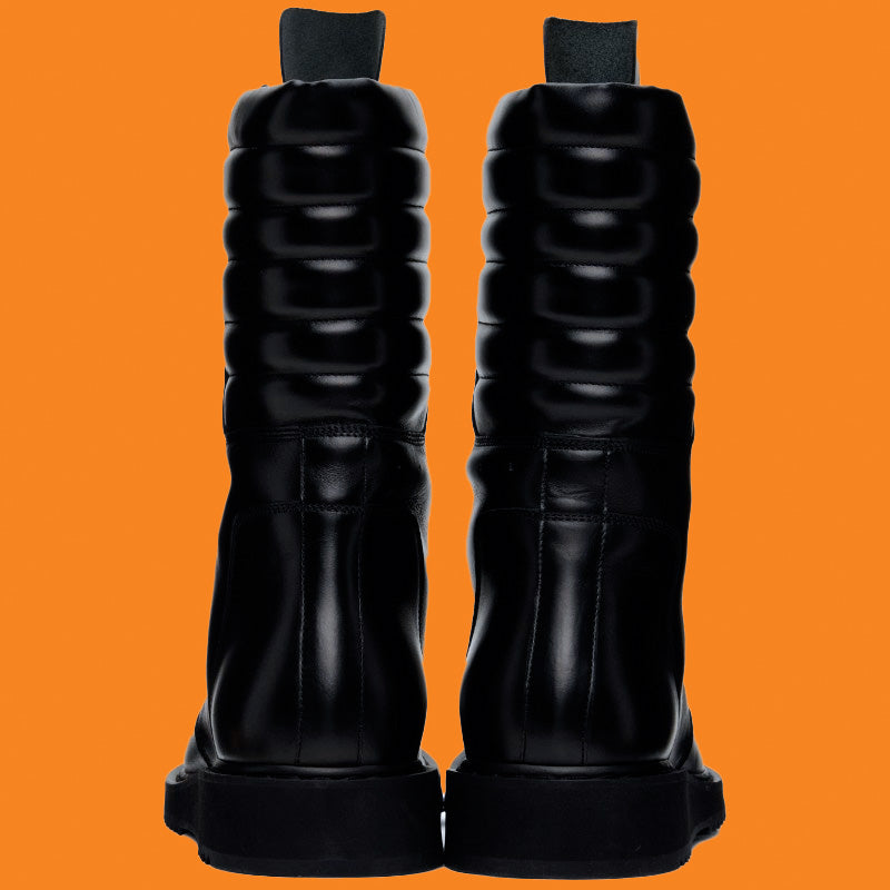 Black knee-high boots on an orange background