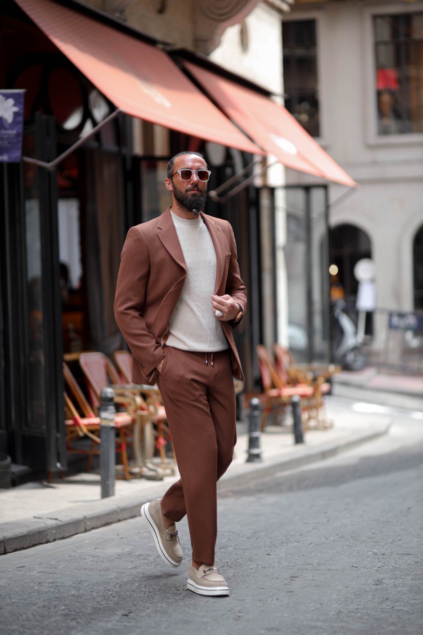 Man in a brown suit walking on a city street