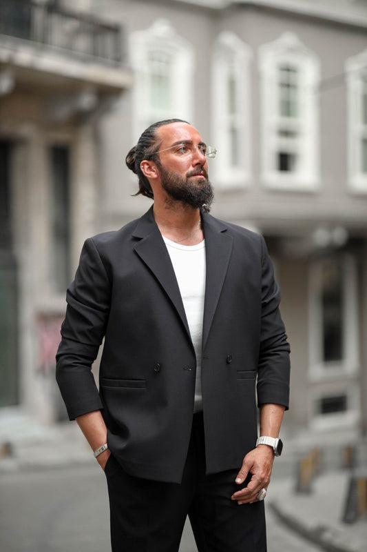 Man wearing a black blazer over a white shirt in an urban setting