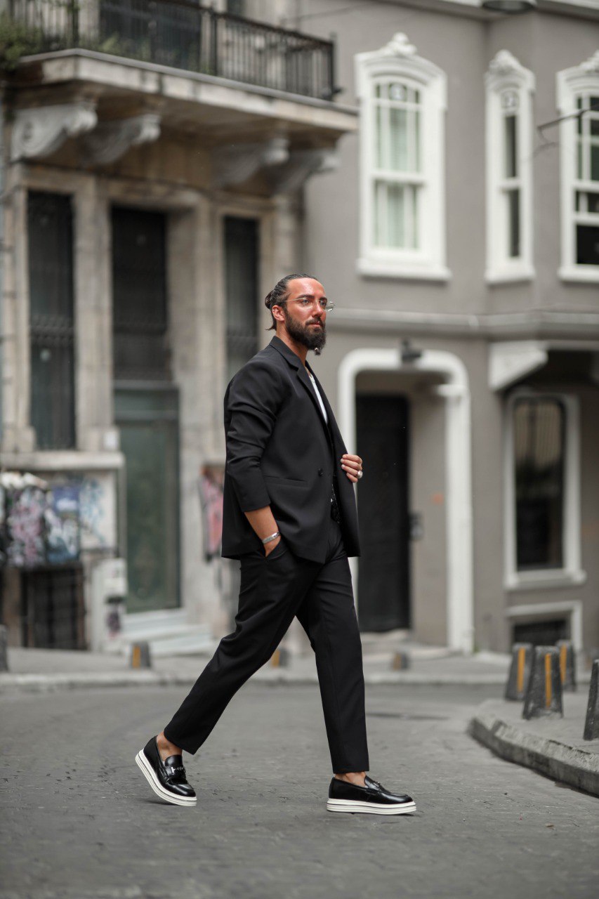 Man in a black suit walking on a city street